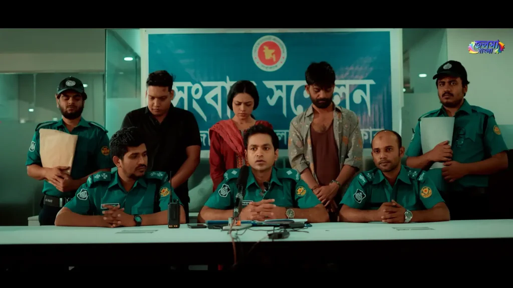 Police officers address the media while three detained individuals stand behind them in a scene from the Bangla drama Harami.