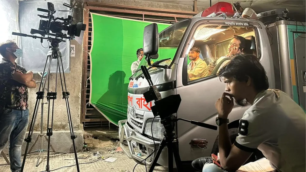 Cameras, lights and a green screen surround a vehicle during an interior scene shoot for Harami.