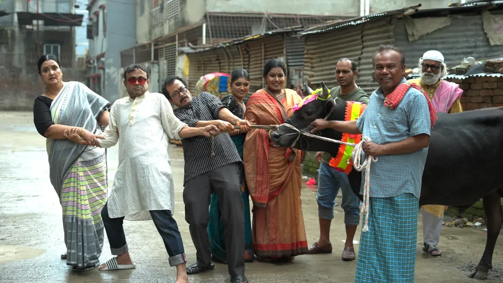 7 Flat er Qurbani production still of residents pulling a decorated cow in a lane