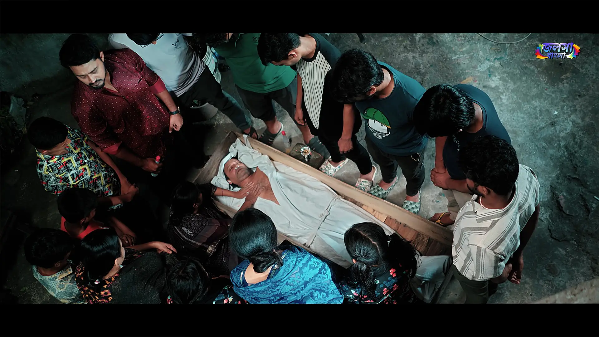 Apon Hoyeo Por drama still of mourners gathered around a man on a wooden cot