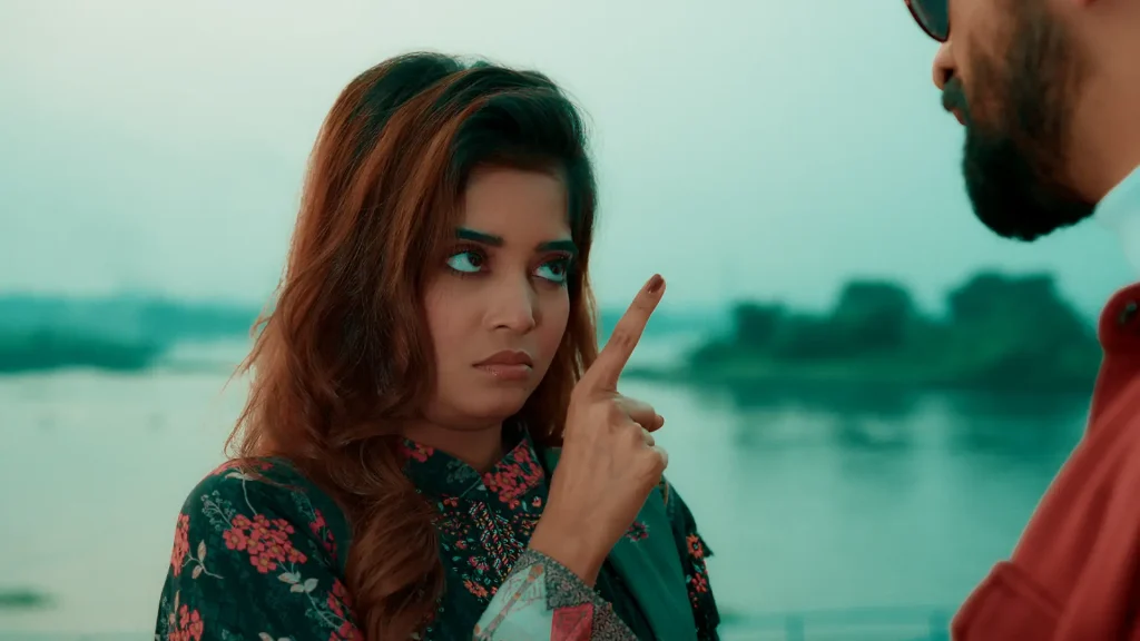 A determined woman raises her finger while confronting a bearded man in the Bangla Full Natok Sei Ami Nei Ami.
